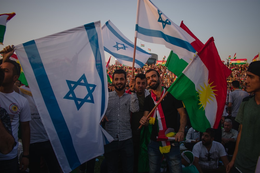 a group of people holding flags in front of a crowd