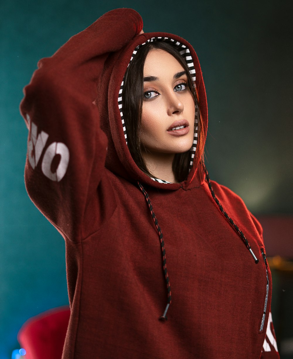 a woman in a red hoodie is posing for a picture