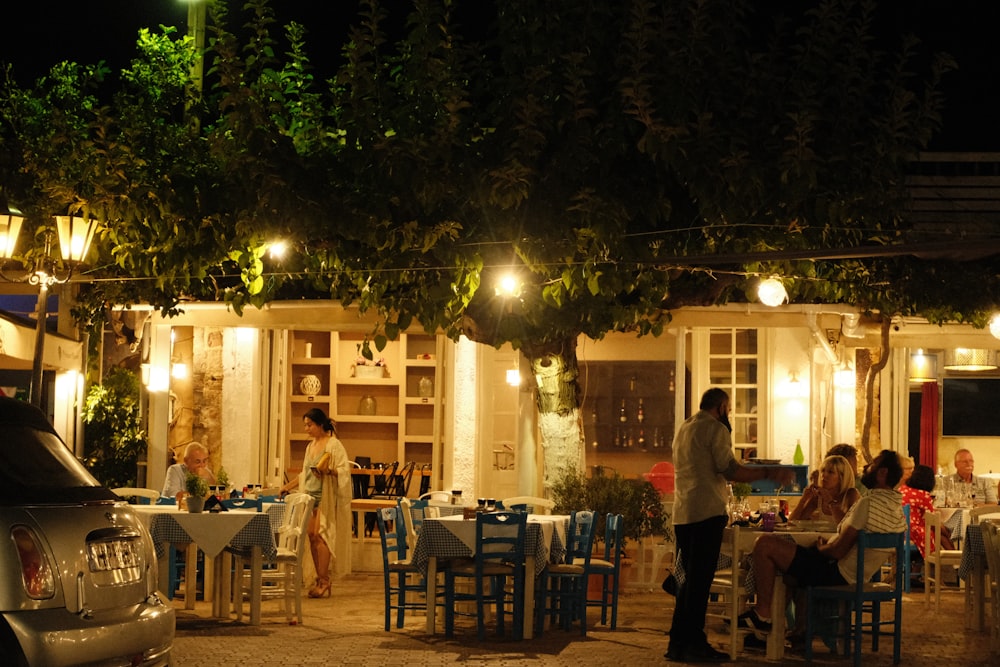 un groupe de personnes assises à une table à l’extérieur d’un restaurant