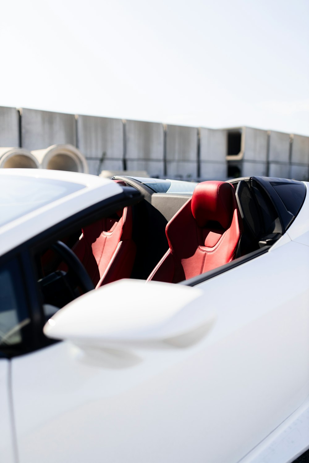 駐車場に赤い座席を持つ白いスポーツカー