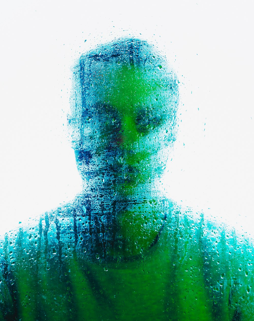 a man standing in front of a window covered in rain