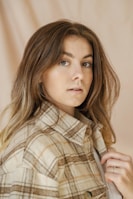 An earthy-toned jacket paired with casual chic accessories on a minimalist background.