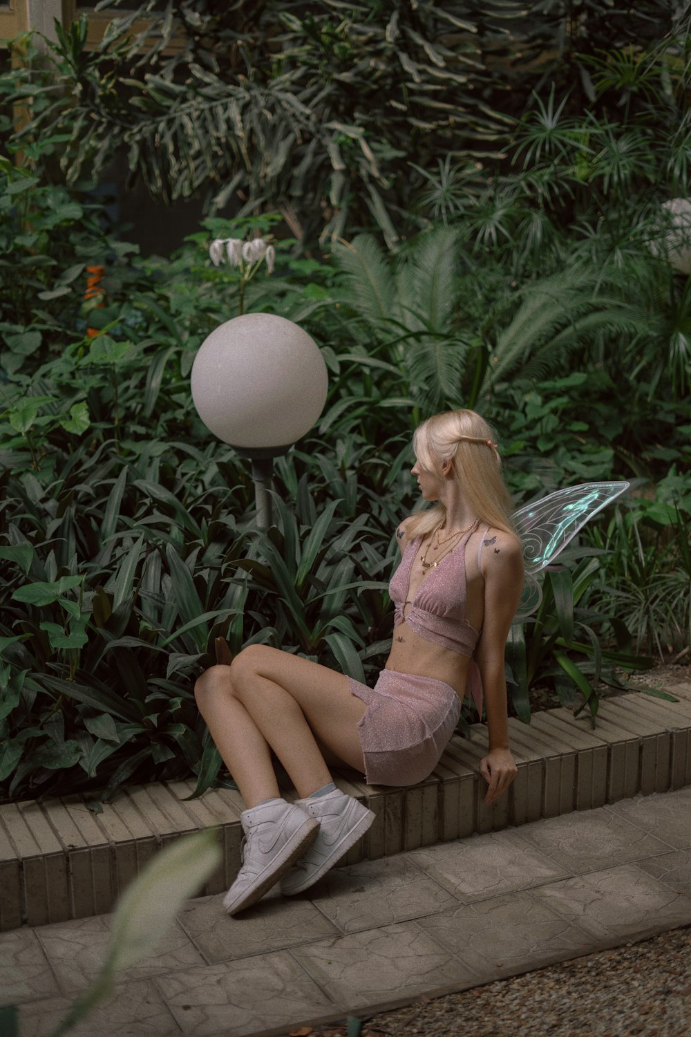 a woman sitting on a brick wall next to a white ball