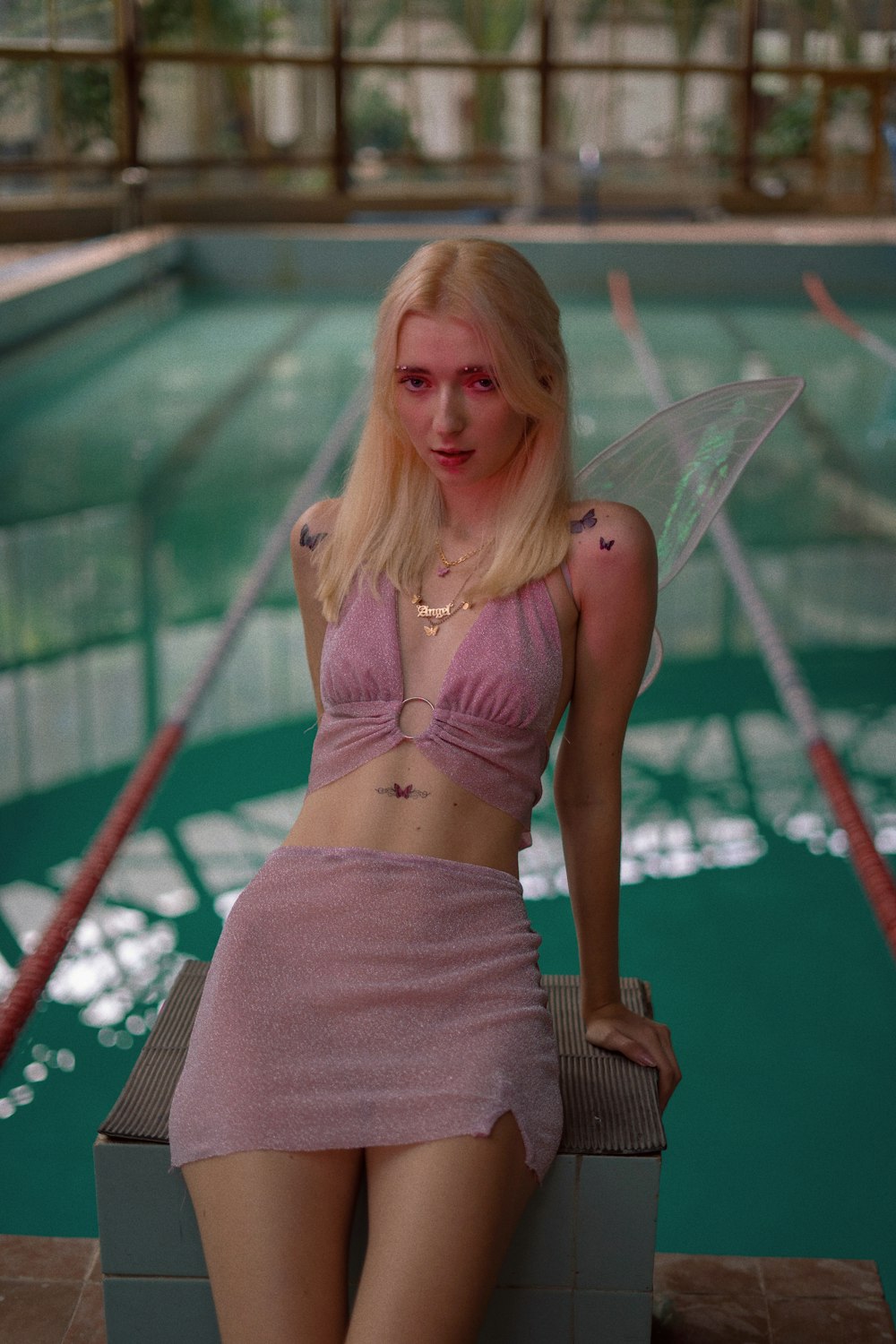 a woman sitting on a box in front of a swimming pool