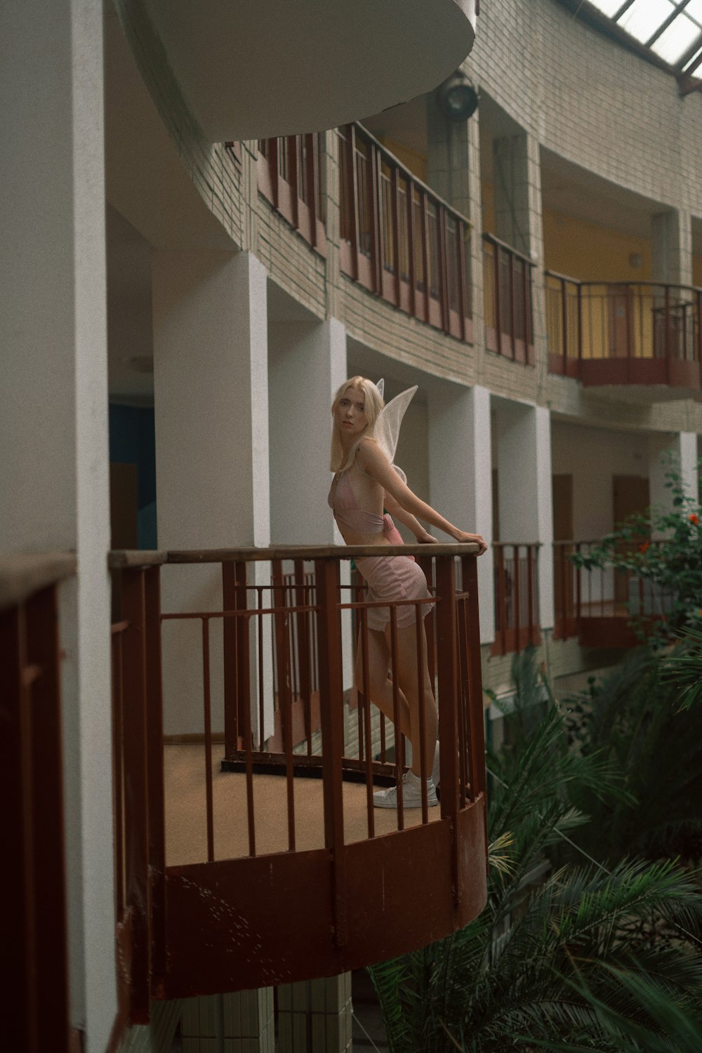 a woman in a pink bathing suit standing on a balcony
