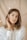 a woman in a white shirt is holding her ear