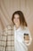 a woman is holding a cup of coffee