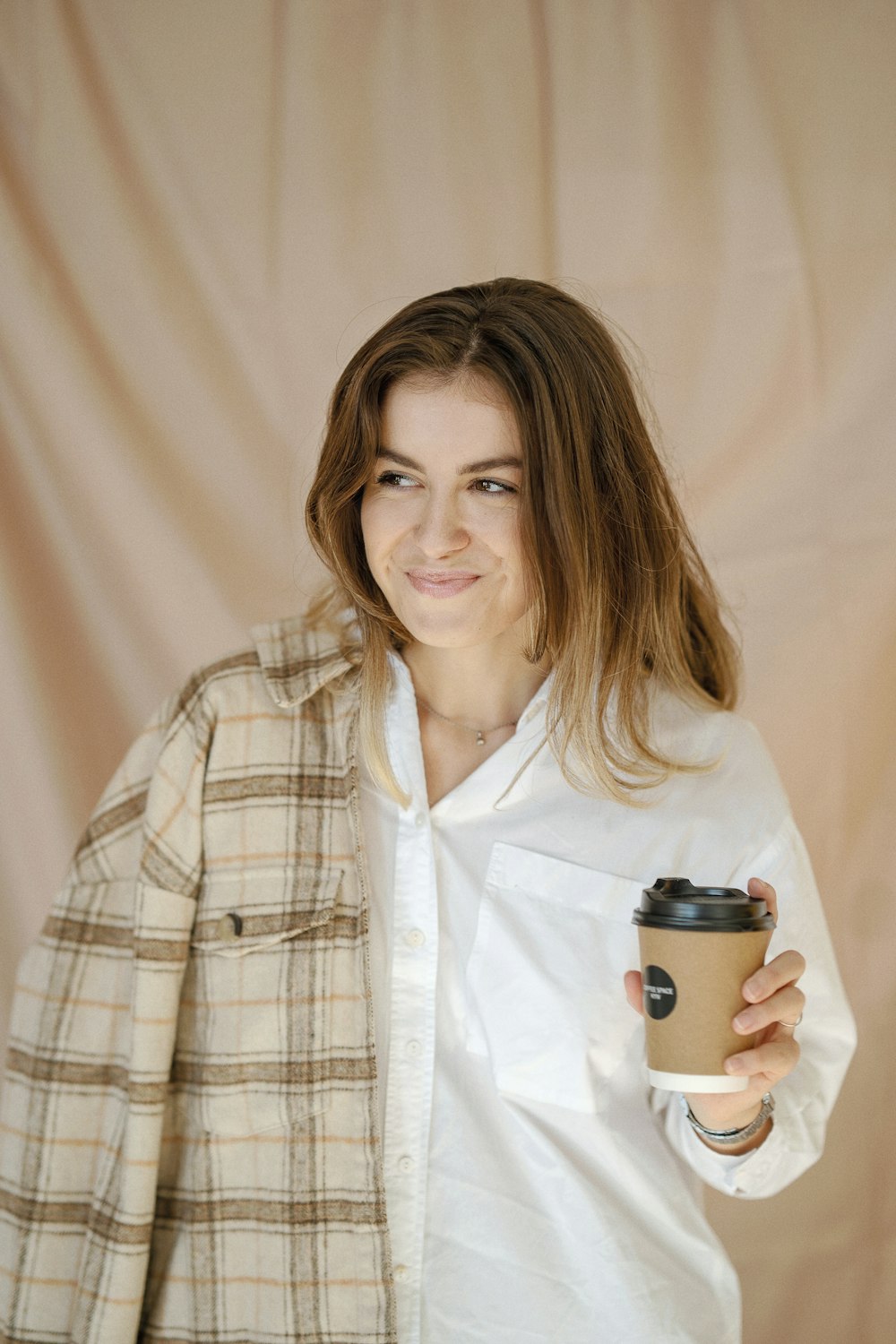 a woman is holding a cup of coffee