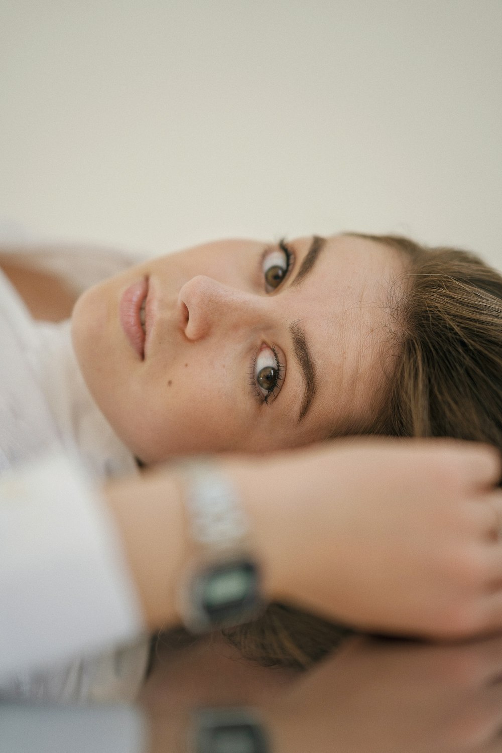 a woman laying on a table with a watch on her arm