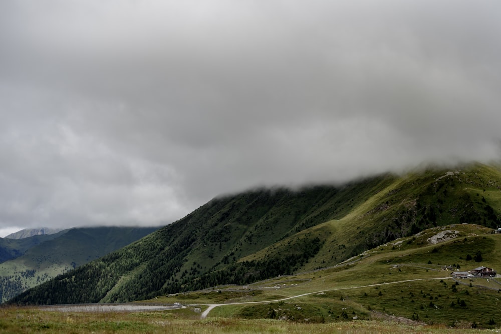 a green mountain with a road going through it