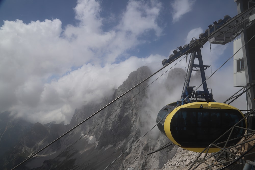 a cable car on a mountain with clouds in the background