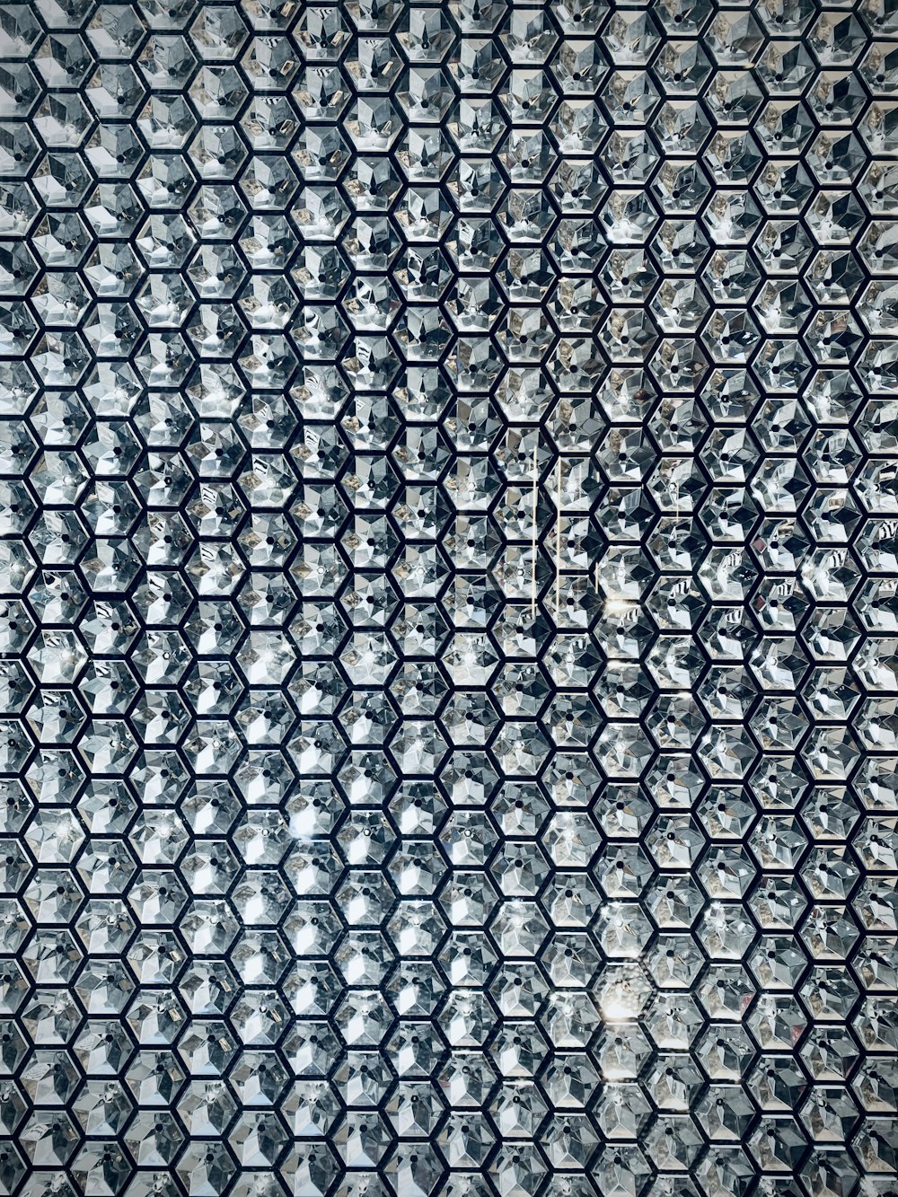 Una foto in bianco e nero di un muro fatto di piastrelle esagonali