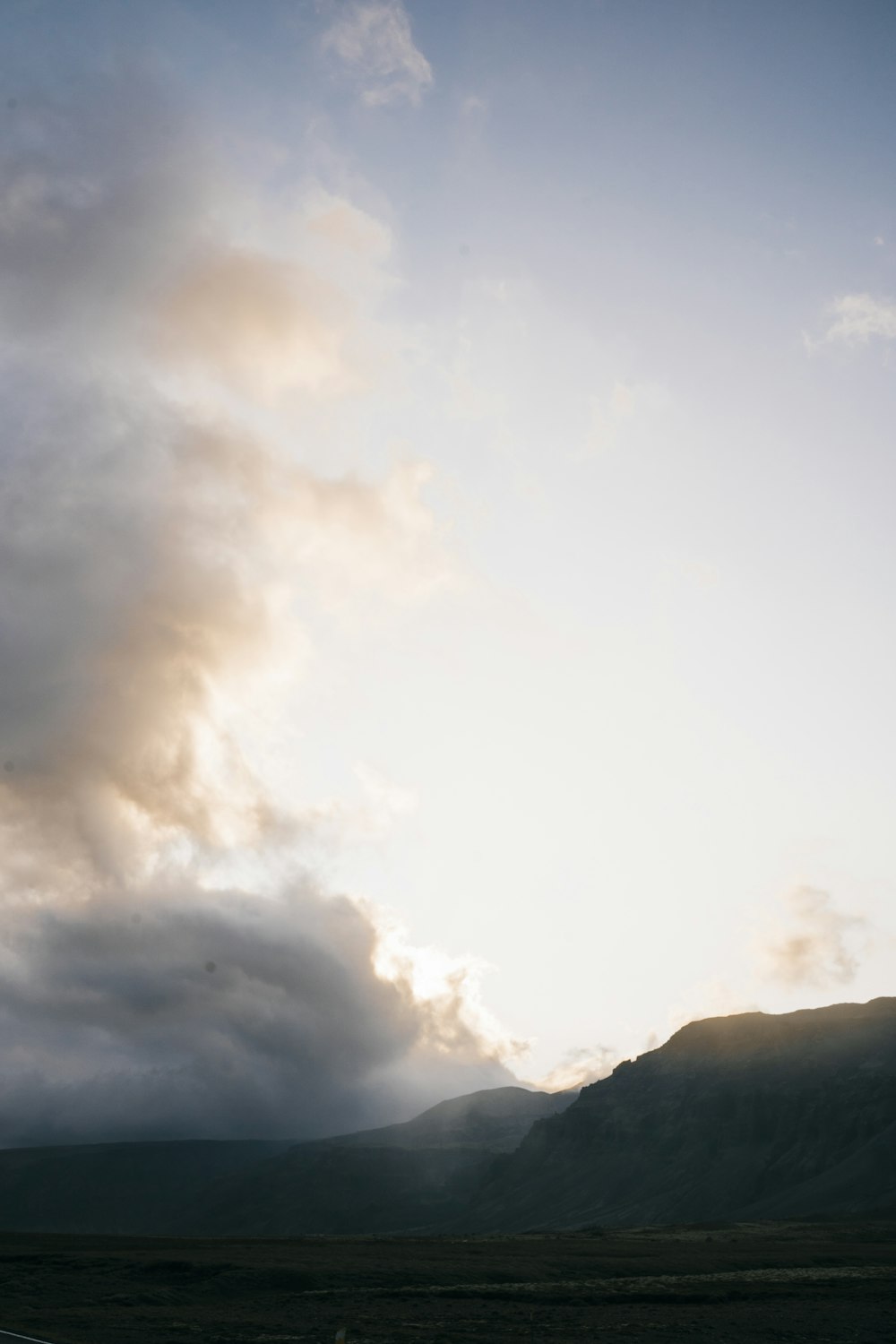 a plane flying in the sky with a mountain in the background