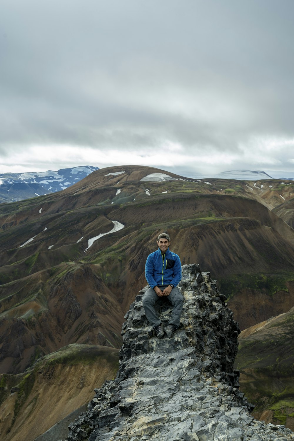 a man sitting on top of a rock formation