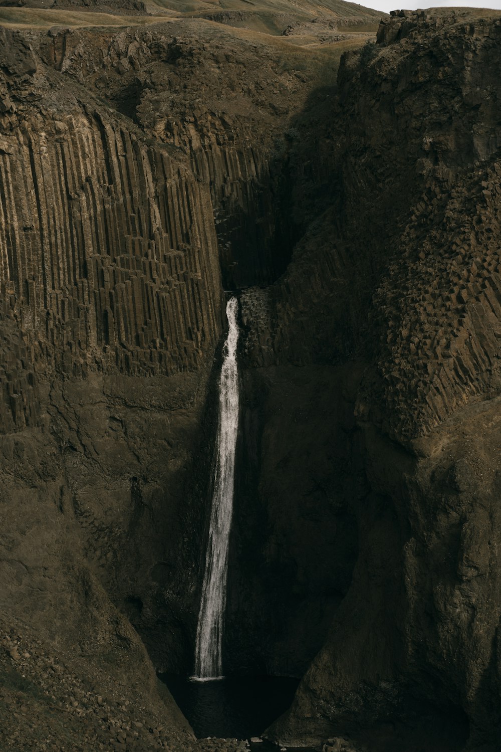 a small waterfall in the middle of a canyon