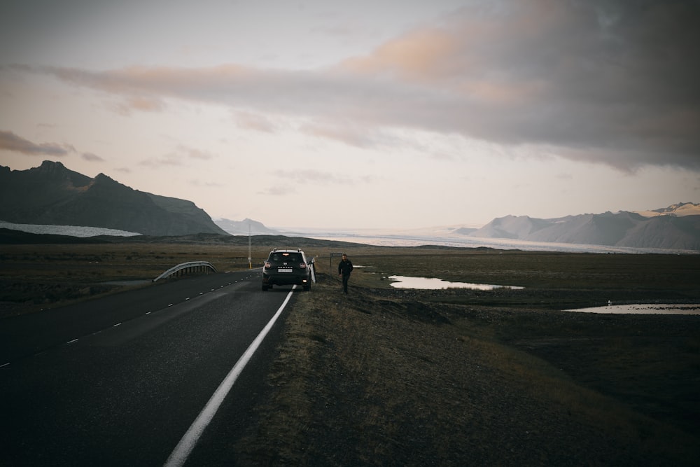 a couple of people standing on the side of a road