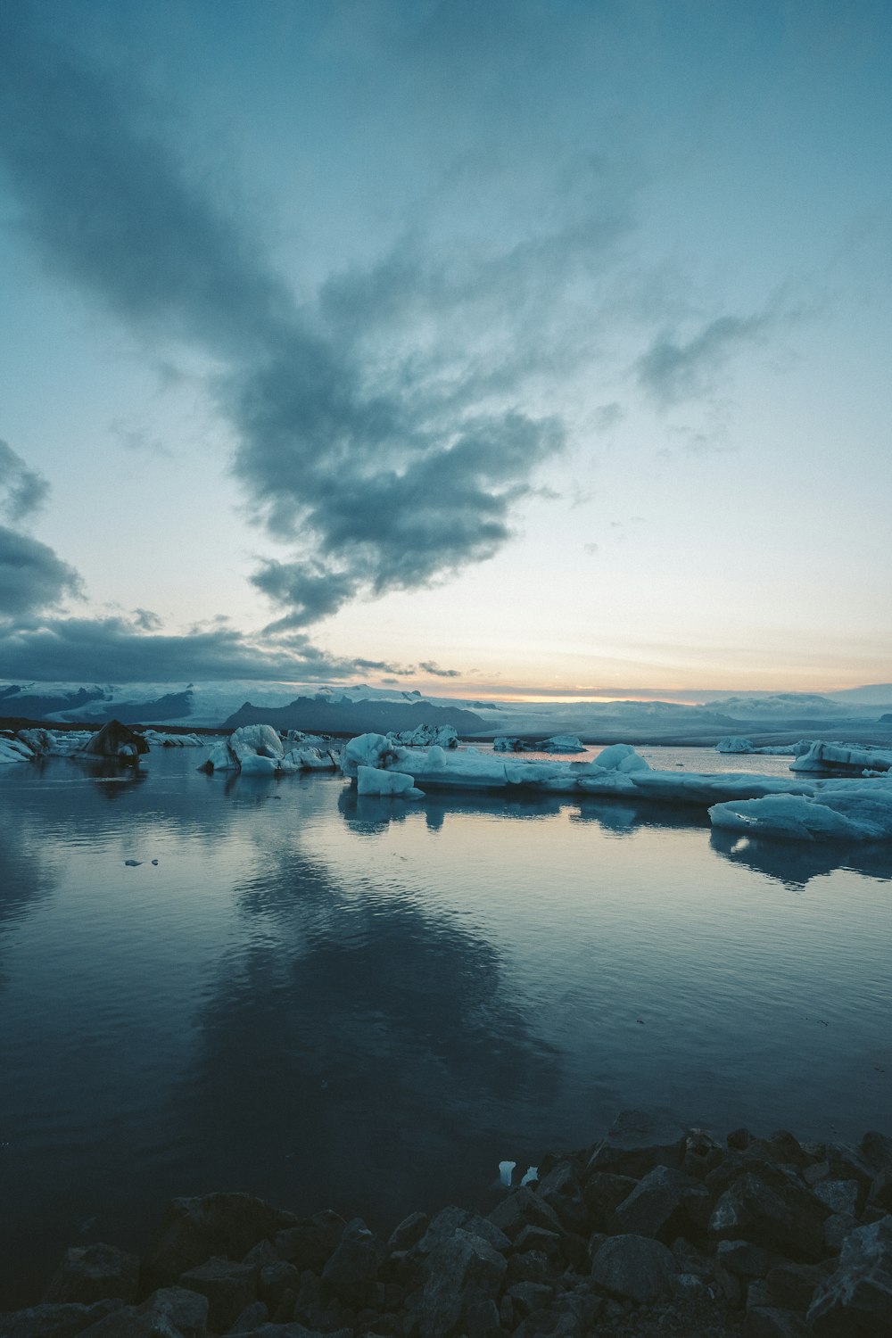 a group of icebergs floating on top of a body of water