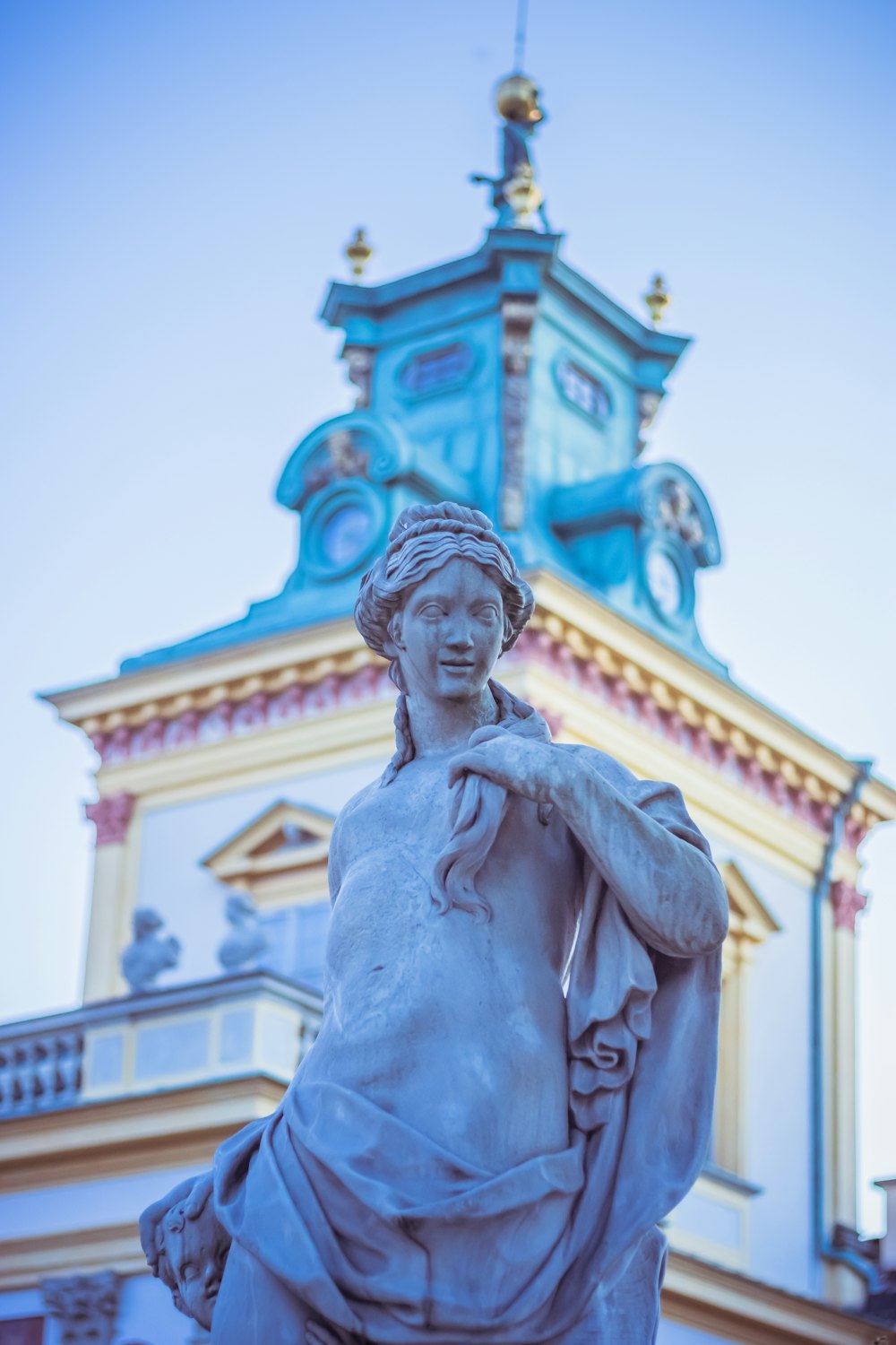 a statue of a woman in front of a clock tower