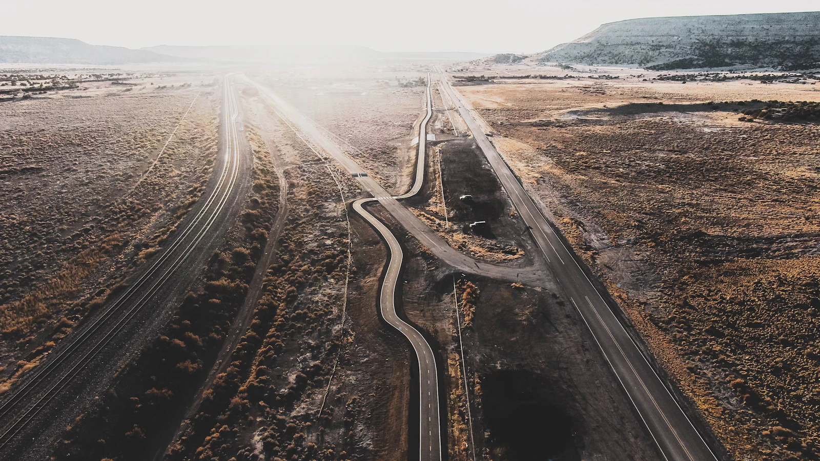Aerial view of a road winding through a desert plain