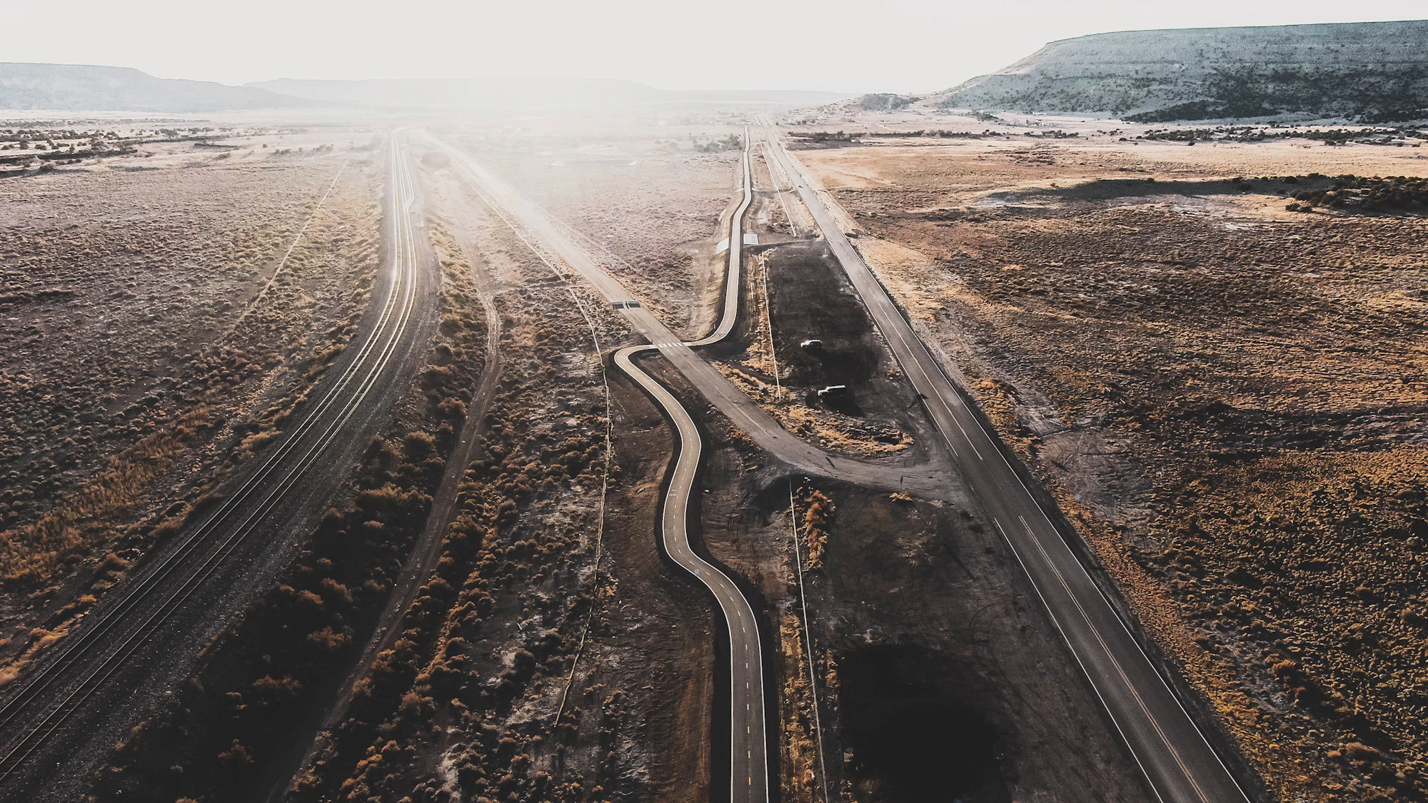 Aerial view of a road winding through a desert plain