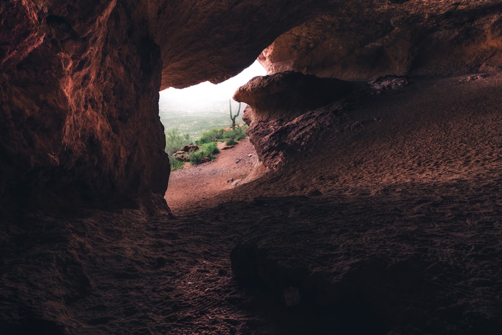 a cave entrance with a view of the valley below