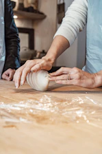 a woman is peeling an onion on a cutting board