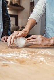 a woman is peeling an onion on a cutting board