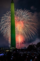 Nighttime view of the illuminated Obelisk with crowds gathering for a local festival