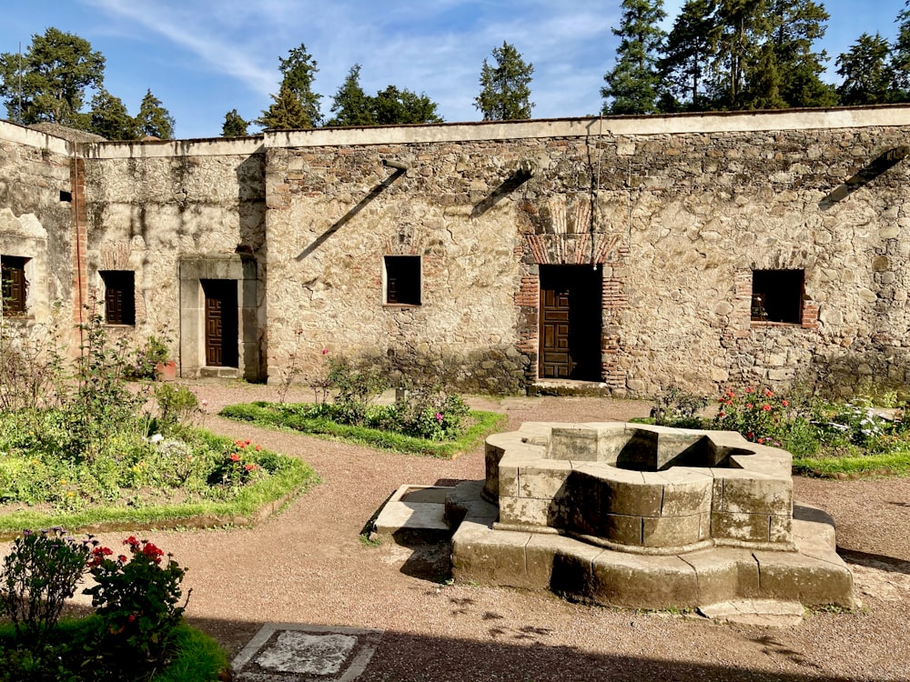 Un edificio de piedra con un jardín frente a él