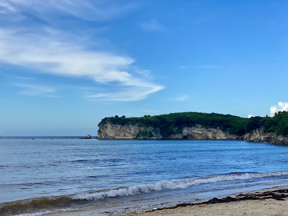 a sandy beach with a small island in the distance