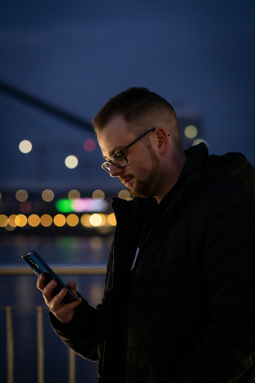 a man looking at his cell phone at night