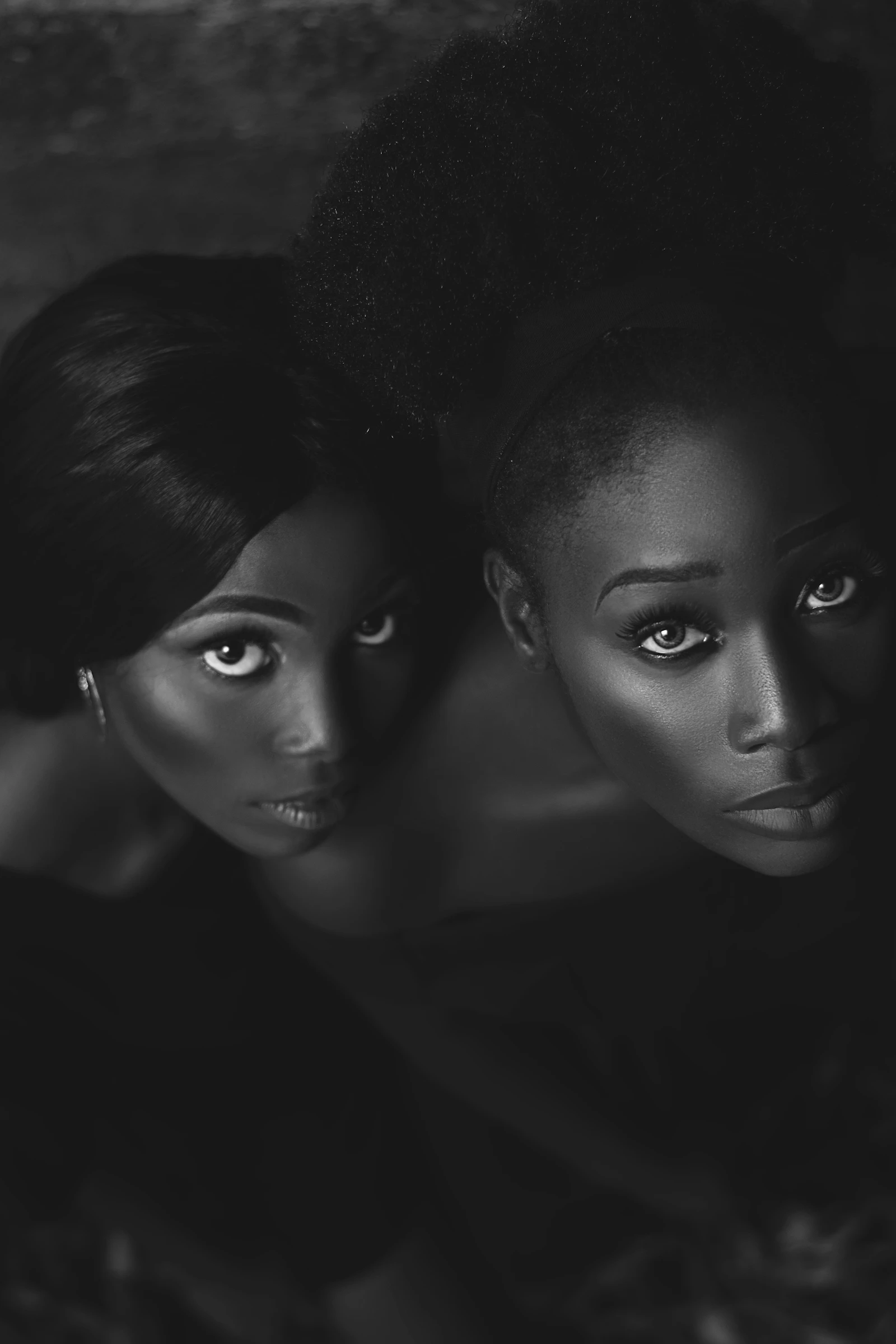 Two Black African women with afro hairstyles in a black and white portrait