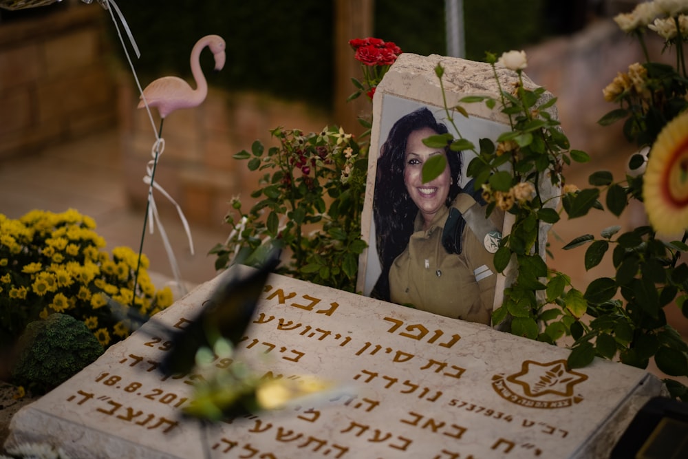 a memorial with flowers and a picture of a woman