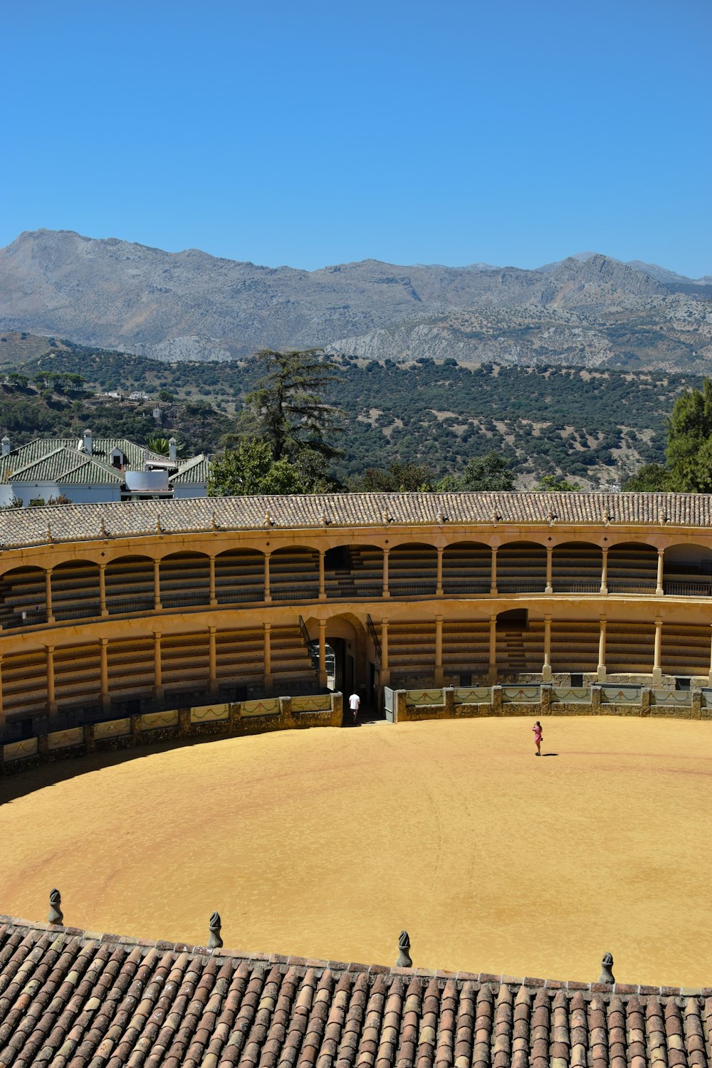 a view of a bull ring with mountains in the background