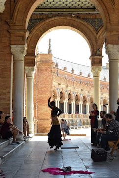 a group of people sitting and standing around a building