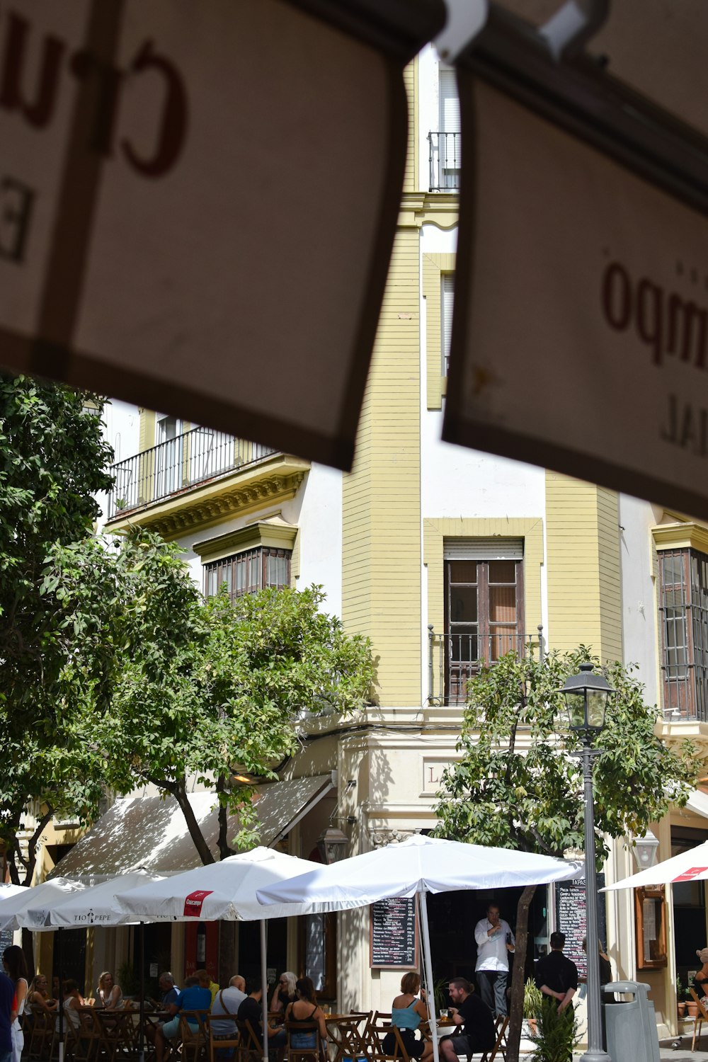 a group of people sitting at tables under umbrellas