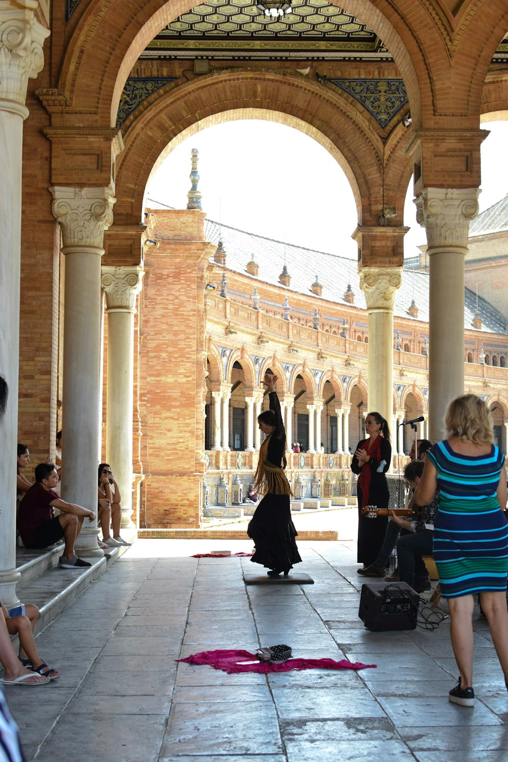 a group of people sitting and standing around a building