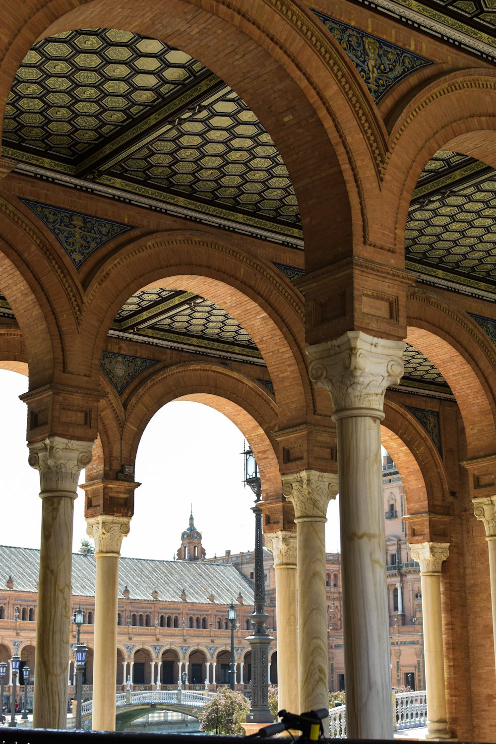 a large building with arches and a clock tower in the background