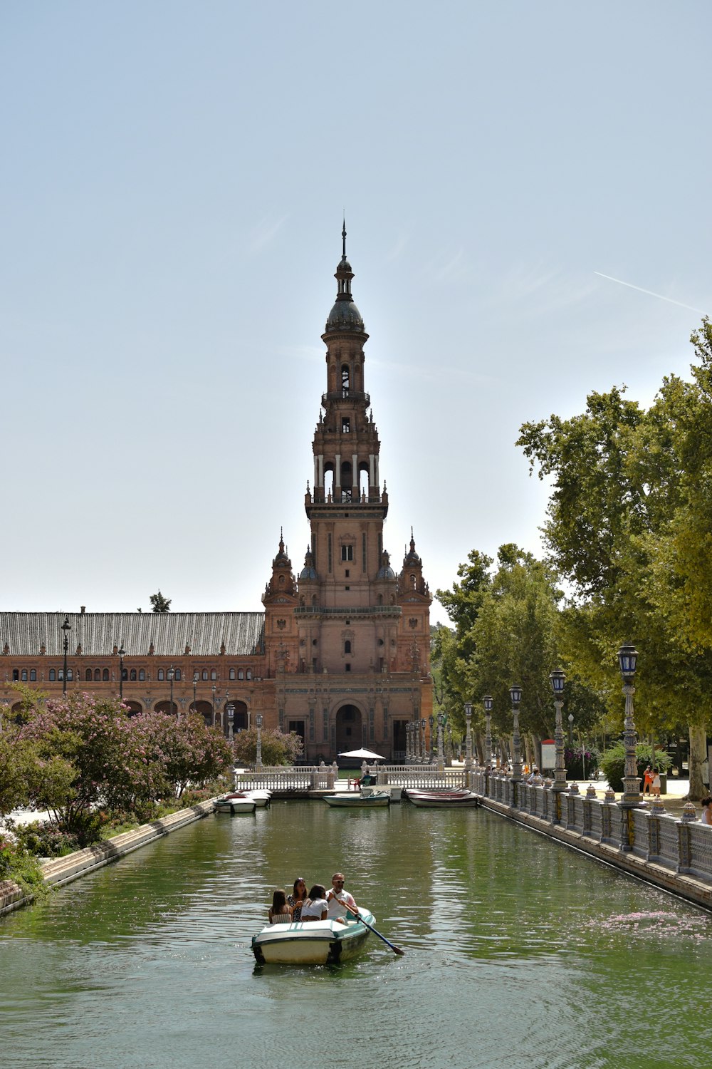 people in a small boat on a river in front of a building