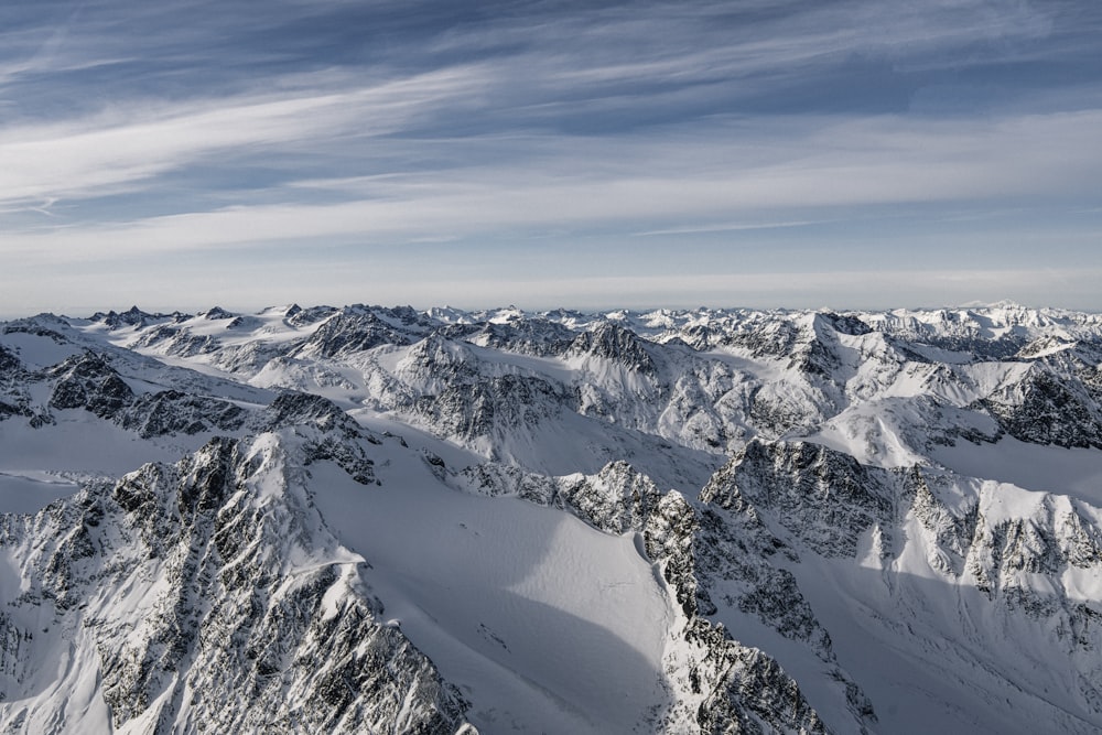 a mountain range covered in snow under a blue sky