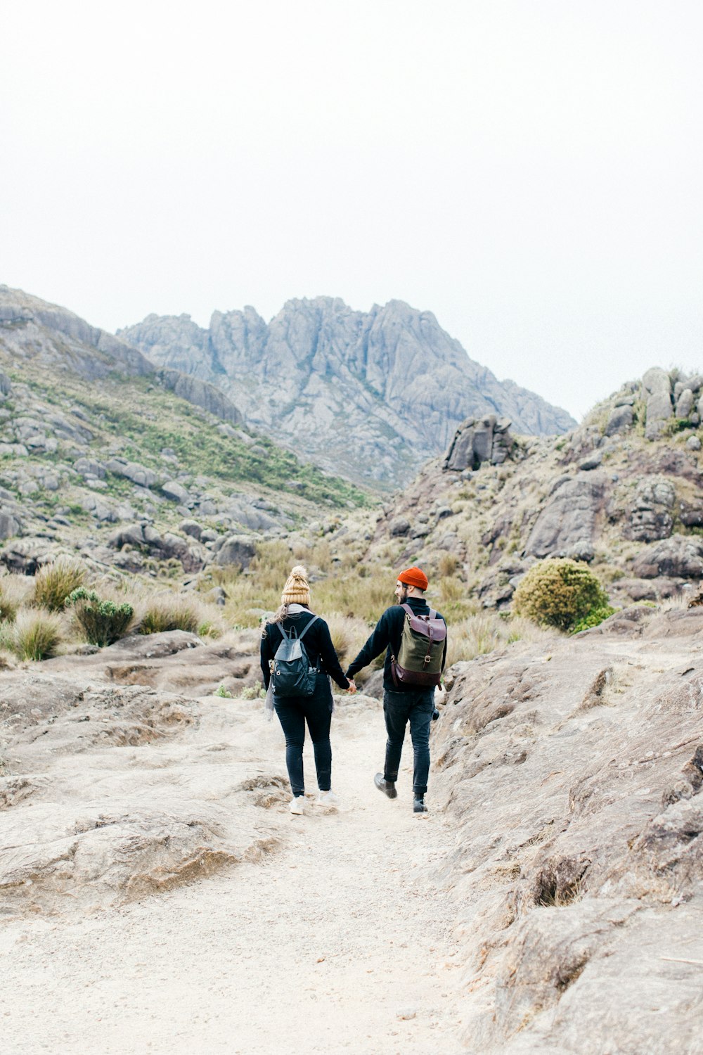 a couple of people walking down a dirt road