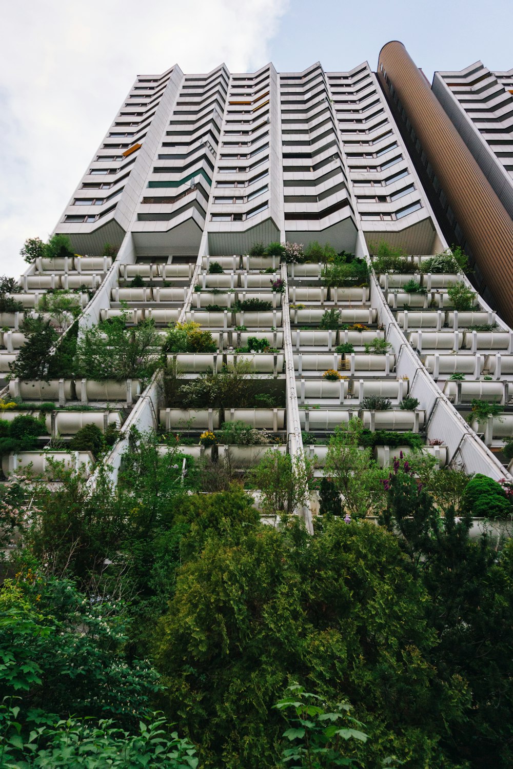 Un edificio muy alto con muchas plantas que crecen en él