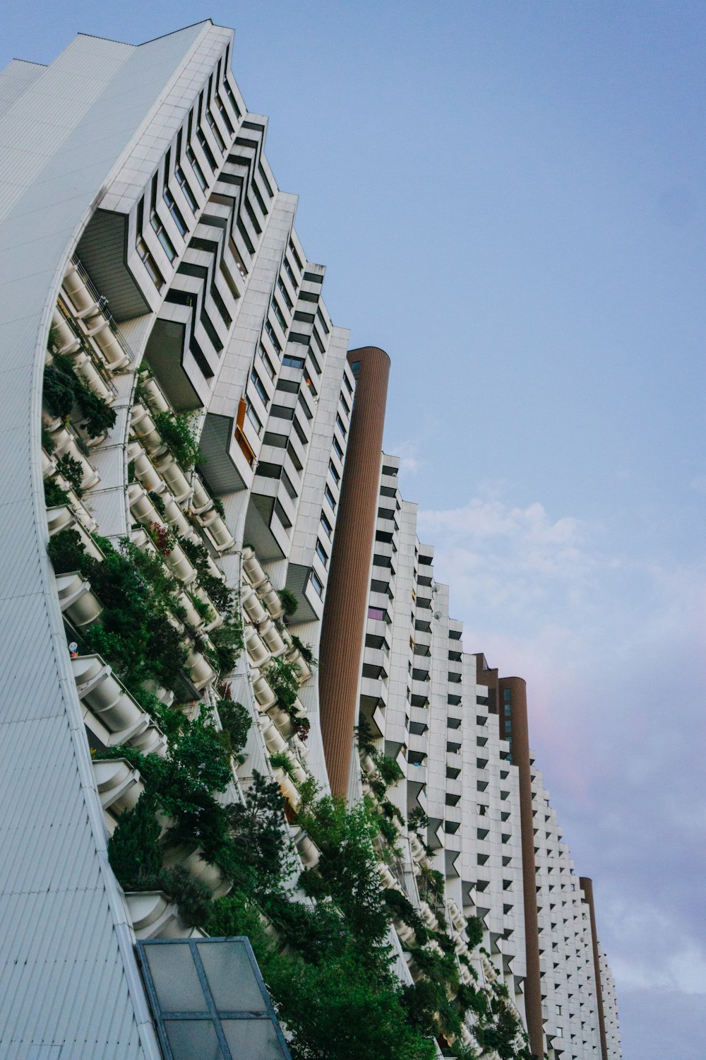 a tall building with plants growing on the side of it