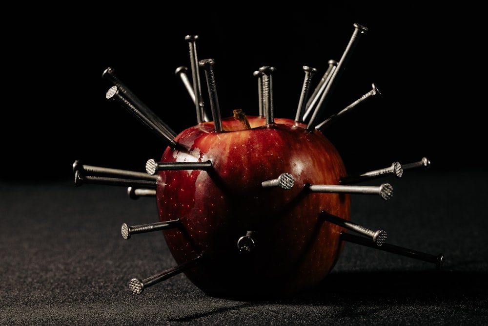 Ein Apfel mit einem Haufen Schrauben drauf