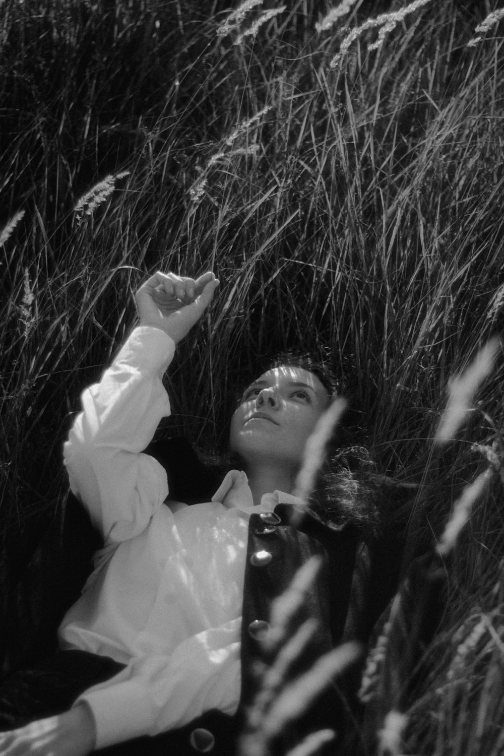 a woman laying in a field of tall grass