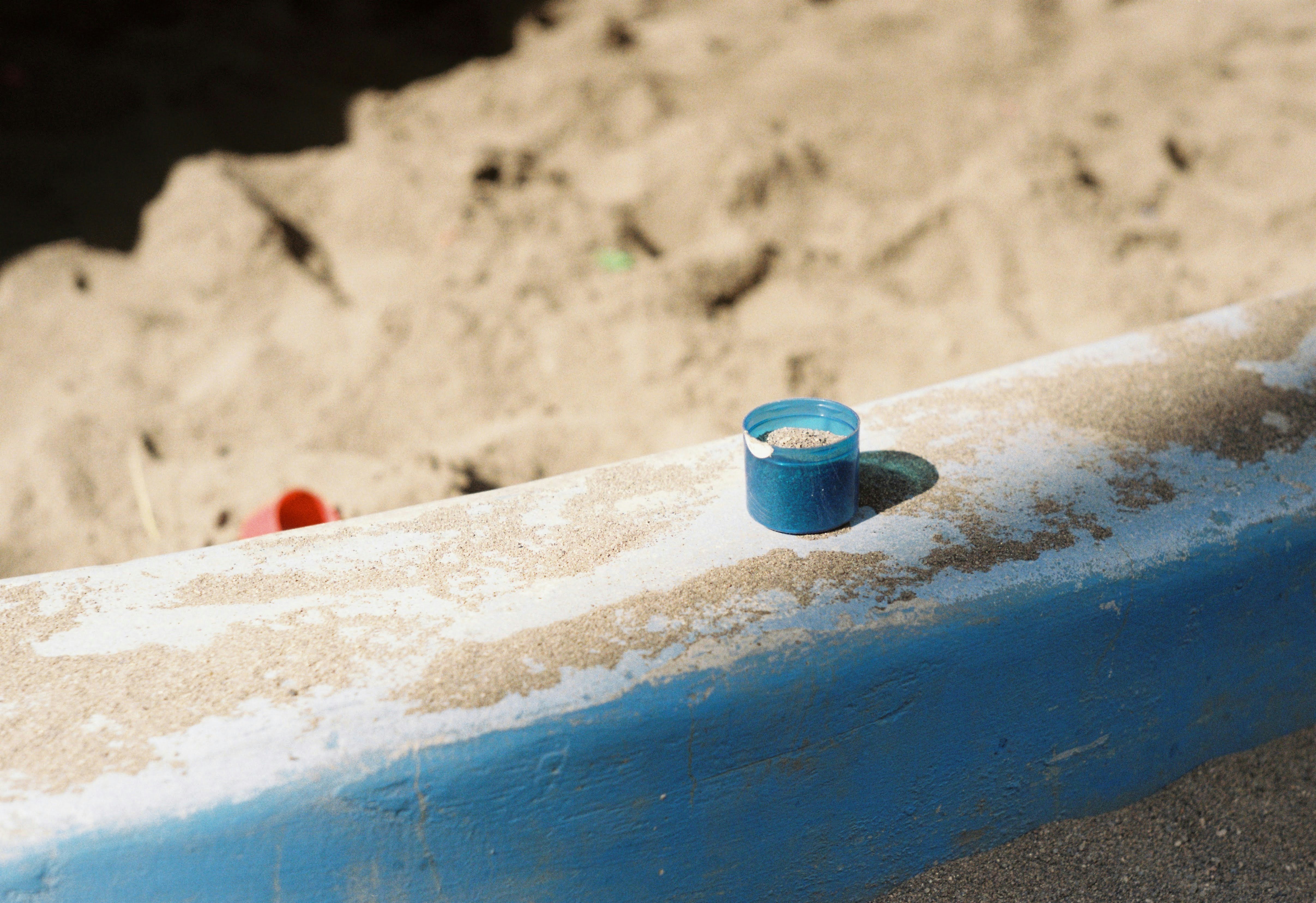 a blue cup sitting on top of a blue surfboard