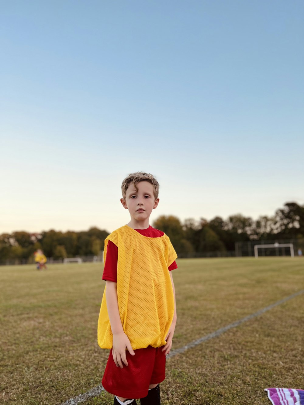 a young boy standing on a soccer field