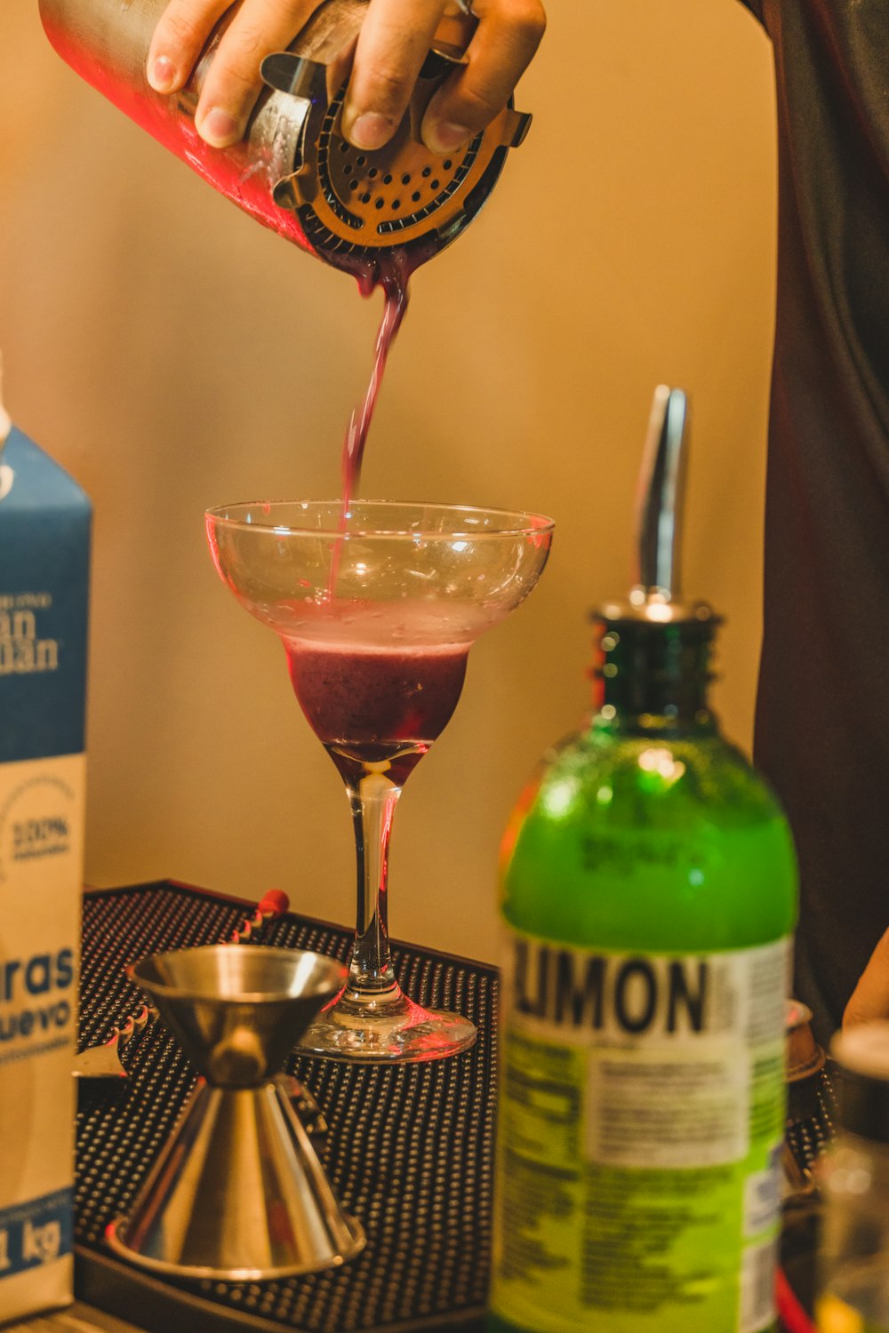 a person pouring a drink into a glass