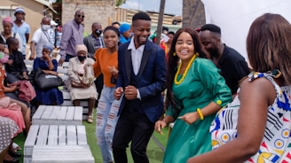 A group of people dancing and celebrating together outdoors.