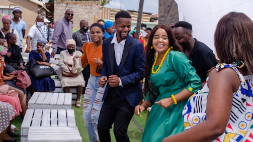 A group of people dancing and celebrating together outdoors.